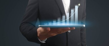 İşadamı, elinde tabletle iş yerinde grafik büyümesi ve grafik artışı planlıyor