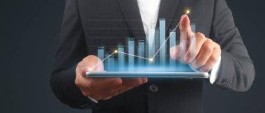 İşadamı, elinde tabletle iş yerinde grafik büyümesi ve grafik artışı planlıyor