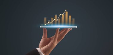 İşadamı, elinde tabletle iş yerinde grafik büyümesi ve grafik artışı planlıyor