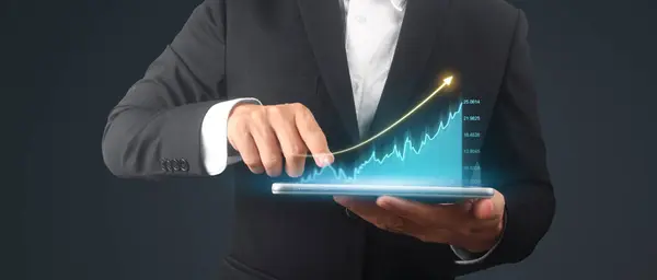 ビジネスマンは グラフの成長と彼のビジネスにおけるチャート正の指標の増加を計画します 手元のタブレット ストック画像