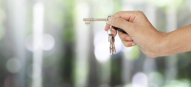 Emlakçı ev anahtarlarını elden teslim ediyor.