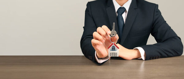 Агент по недвижимости передает ключи от дома в руки