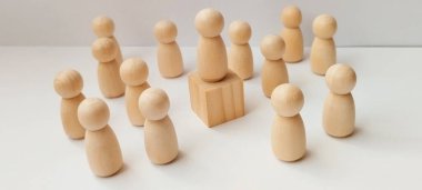 Tahta figürler arasında liderlik toplanıyor. Minimalist, kavramsal sanat, yaratıcı sosyal dinamikler kuruyor.