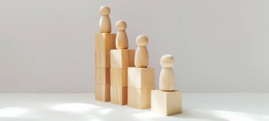 Başarılı ahşap figürler minimalist stüdyoda bloklara tırmanıyor. Büyüme ve başarı için ilham veriyor.
