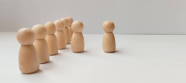 Ahşap figürler arasında grup dinamiği ve bireysellik kavramsal fotoğrafçılık ayarlayan minimalist figürler.