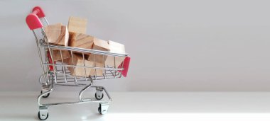 Karton kutularla dolu alışveriş arabası. Perakende ürün fotoğrafçılığı. Minimalist tasarım yan görüş e-ticaret kavramı.