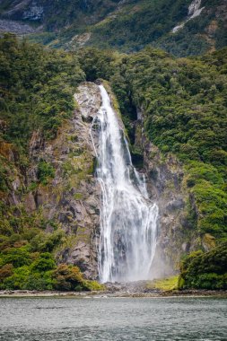 Bowen Falls cascading over rocks into Milford Sound in Fiordland on the South Island of New Zealand