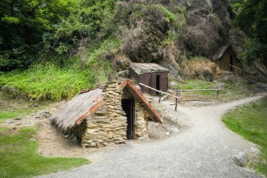 Arrowtown, Otago, Yeni Zelanda - 20 Aralık 2022: 1880 'lerde Yeni Zelanda' nın Arrowtown kentindeki Bush Deresi 'nin kıyısındaki Çin altın madenciliğinde bir grup küçük ev