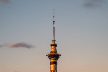 Auckland, New Zealand - December 27th 2022: Evening sun lighting up Sky Tower, a 328m tall telecommunications and observation tower in Auckland, New Zealand