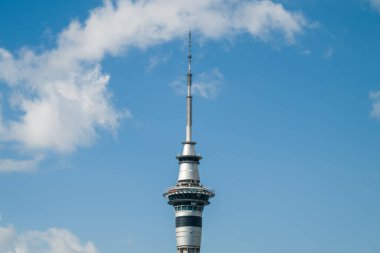 Auckland, New Zealand - December 27th 2022: A group of walkers in orange jumpsuits experience the SkyWalk at the top of Sky Tower, a 328m tall telecommunications and observation tower in Auckland, New Zealand