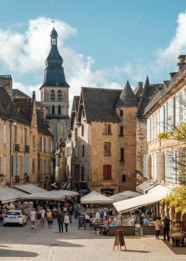 Sarlat-la-Caneda, Fransa - 19 Eylül 2023: Fransa 'nın Dordogne bölgesindeki Sarlat-la-Caneda pazar meydanındaki bar, kafe, restoran ve dükkanlarda gezinti yapan ziyaretçiler