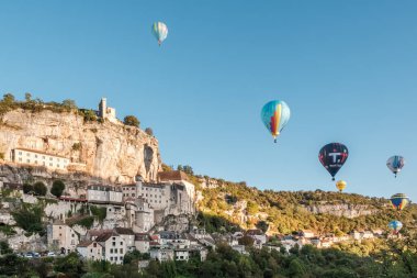 Rocamadour, Fransa - 24 Eylül 2023: Montgolfiades de Rocamadour balon festivali sırasında Fransa 'nın Lot bölgesindeki ortaçağ Rocamadour kasabasından sıcak hava balonları geçti