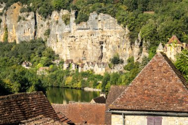 Fransa 'nın en güzel köylerinden biri olan La Roque-Gageac' ın çatıları üzerindeki Dordogne nehri kıyısındaki evlerin manzarası.
