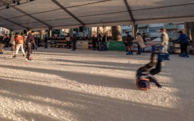 Sarlat-la-Caneda, Nouvelle-Aquitaine, Fransa - 16 Aralık 2023: Fransa 'nın Dordogne bölgesindeki Sarlat-la-Caneda Noel pazarında bir patenci buz pateni pistine düştü