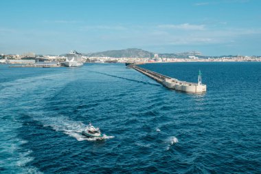 Marsilya, Fransa - 24 Mayıs 2024: Fransa 'nın güneyindeki Marsilya limanından limana demirlemiş büyük bir yolcu gemisiyle ayrılan pilot tekne