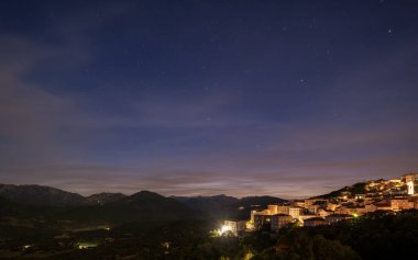 Night time over the town of Sartene in southern Corsica with the Bavella mountains in the distance clipart