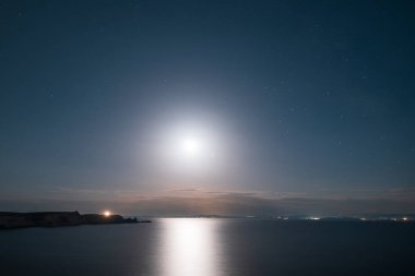 Dolunay, Korsika 'nın güney kıyısındaki Bonifacio ve Akdeniz uçurumlarının üzerinde gece gökyüzünü aydınlatıyor.