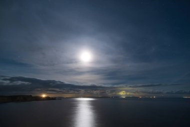 Dolunay, Korsika 'nın güney kıyısındaki Bonifacio ve Akdeniz uçurumlarının üzerinde gece gökyüzünü aydınlatıyor.