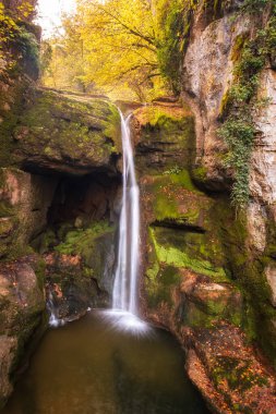 Moulin du Saut Şelalesi, Fransa 'nın Lot bölgesindeki Alzou nehrinin sonbahar renklerinde bir ormanında 18. yüzyıldan kalma terk edilmiş bir değirmen.