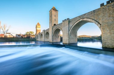 Fransa 'nın Cahors kentindeki nehir arazisini geçen bir UNESCO Dünya Mirası Alanı olan 14. ve 15. yüzyıl Valentre köprüsü altında çağlayan sular.