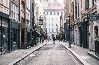 Londra, İngiltere - 28 Nisan 2025: İnsanlar sabahın erken saatlerinde Soho, Londra 'daki Bateman Caddesi boyunca işe gidiyorlar