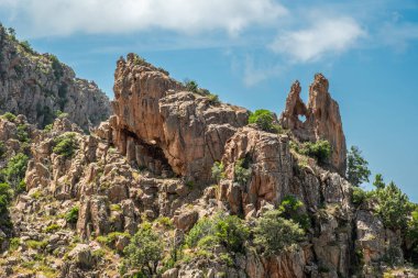 Akdeniz 'in batısındaki Korsika adasının batı kıyısındaki UNESCO miras alanı olan Calanches de Piana' da kalp şeklinde bir delik olan dramatik bir kaya oluşumu.