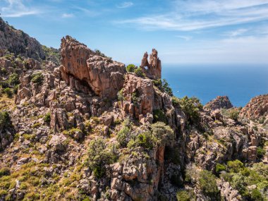 Akdeniz 'in batısındaki Korsika adasının batı kıyısındaki UNESCO miras alanı olan Calanches de Piana' da kalp şeklinde bir delik olan dramatik bir kaya oluşumu.