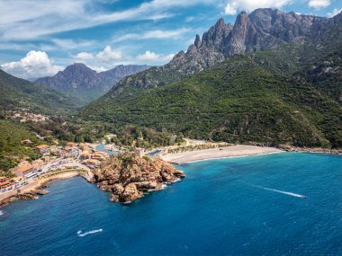 Genoise kulesinin kayalık bir çıkıntıdaki havadan görünüşü ve Akdeniz 'in batı kıyısındaki Porto sahilinde arkasında dağlarla birlikte Korsika adasının