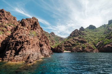 Kıyı şeridi, pürüzlü kayalar ve 1975 yılında Akdeniz 'in Korsika adasının batı kıyısında kurulan Scandola Doğa Rezervi' nde küçük kumlu bir sahil.