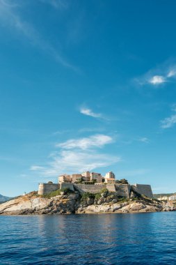 Orta Çağ Kalesi, Akdeniz 'in batı kıyısında, üzerinde mavi gökyüzü olan Korsika adası.