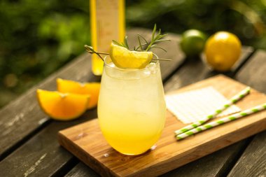 Limonlu misket limonlu ev yapımı limonata ve doğadaki ahşap masada meyve süslemeli bir bardak.