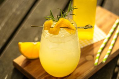 Limonlu misket limonlu ev yapımı limonata ve doğadaki ahşap masada meyve süslemeli bir bardak.