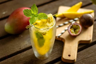 Mangolu ev yapımı limonata. Doğadaki ahşap masada meyve ve süslemeli.