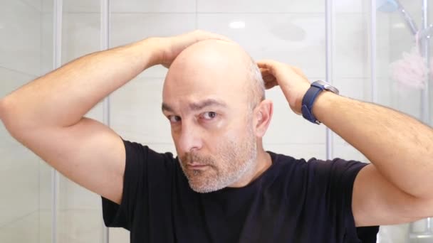 男人在镜子前面的浴室里看着自己 中年男人生气了 因为他的头发掉光了 — 图库视频影像