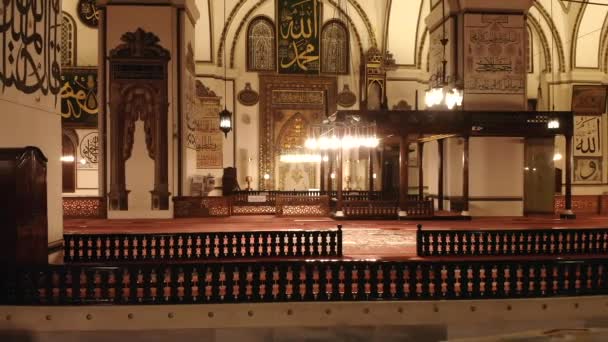 巨大な歴史的な偉大なモスクの内部 ミナレットのマスジド神秘的な神の宗教神秘的な永遠の宗教礼拝の宗教的なイスラムの場所美しい美しさのパターンの入り口唐草書道の壁の祈りのアーキテクチャグランドモスクブルサUlu Camii — ストック動画