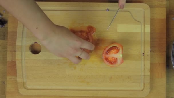 女人们在木制厨房桌旁切西红柿实用的切碎机菜谱女女士美味佳肴配餐木桌桌上水果蔬菜刨花板格栅手磨子营养 — 图库视频影像