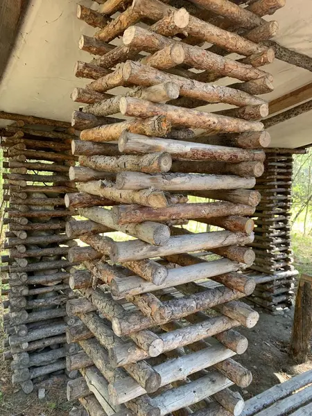 Stock image A rustic log cabin model showcasing intricate woodwork, standing 8 feet tall with a square base and a slanted rectangular roof. A creative and detailed display of traditional craftsmanship.