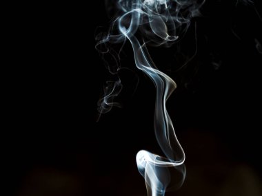 Siyah Arkaplan 'a karşı ruhani duman girdabı. Zarif beyaz bir duman izinin büyüleyici bir fotoğrafı. Derin siyah bir arkaplanda zarifçe kıvrılıyor.. 