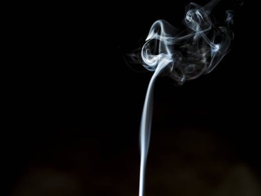 Siyah Arkaplan 'a karşı ruhani duman girdabı. Zarif beyaz bir duman izinin büyüleyici bir fotoğrafı. Derin siyah bir arkaplanda zarifçe kıvrılıyor.. 