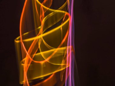 Karanlık arka planda renkli ışık izleri. Parlak renklerde dönen soyut ışık yolları. Işık resminin bulanık hareketinin ormanları. Geceleri bulanık ışıklar. Kasıtlı kamera hareketi, ICM sahnesi