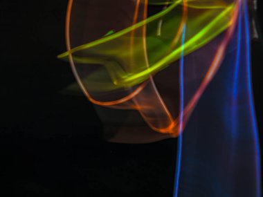 Karanlık arka planda renkli ışık izleri. Parlak renklerde dönen soyut ışık yolları. Işık resminin bulanık hareketinin ormanları. Geceleri bulanık ışıklar. Kasıtlı kamera hareketi, ICM sahnesi