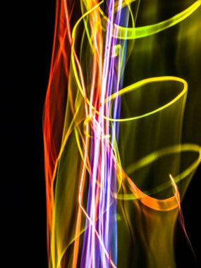 Siyah arkaplanda renkli neon ışık çizgileri. Parlak renklerde dönen soyut ışık yolları. Işık resminin bulanık hareketinin ormanları. Geceleri bulanık ışıklar. Kasıtlı kamera hareketi, ICM sahnesi