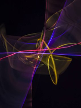 Siyah arkaplanda renkli neon ışık çizgileri. Parlak renklerde dönen soyut ışık yolları. Işık resminin bulanık hareketinin ormanları. Geceleri bulanık ışıklar. Kasıtlı kamera hareketi, ICM sahnesi