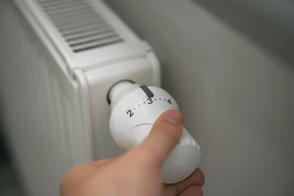 Cutting heating costs in households during the energy crisis. Close-up of heating thermostat in the minimalistic interior.
