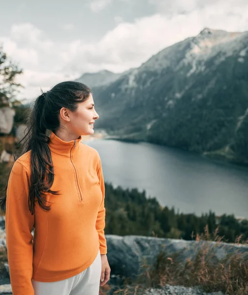 stock image Hiker girl standing at the top. Successful woman hiker open arms on a mountain top. Girl in a sports outfit in the mountains.