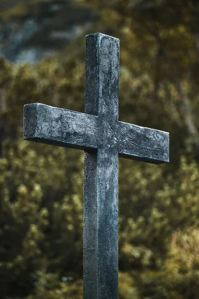 A wooden cross in the mountains on a tourist track.