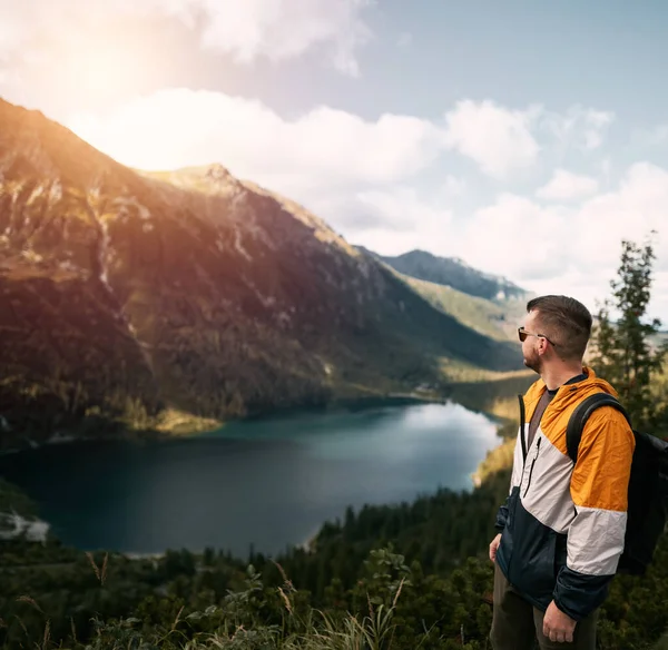 有胡子的年轻高加索人在山顶上 背景山水秀丽 夕阳西下 一个人站在湖上的石崖上 自由和力量的概念 — 图库照片