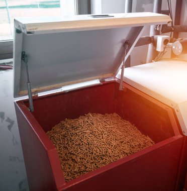 Meşe topaklarıyla dolu pelet sobası. Alternatif yakıt kavramı. Yenilenebilir eko enerjili ısıtma evi.