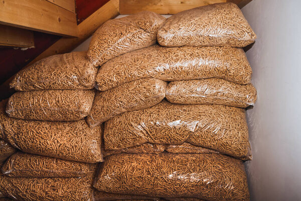 Большие стопки пластиковых пакетов, полных деревянных гранул. Устойчивое топливо будущего.