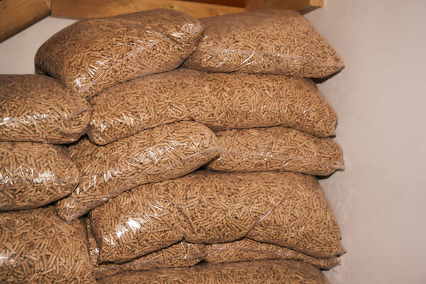 Куча мешков с деревянными гранулами.